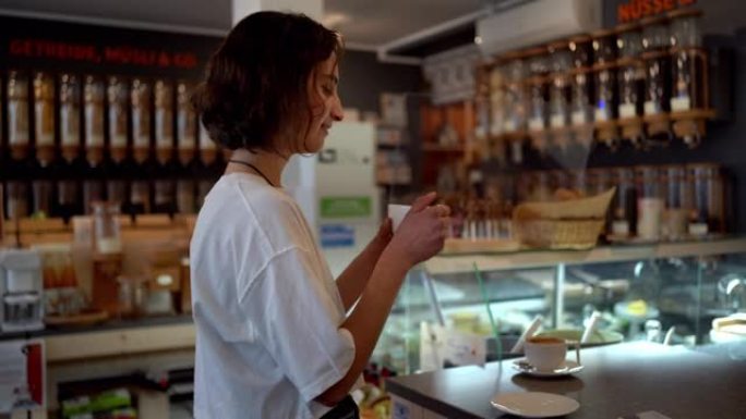 年轻女子在商店里闻到一杯有机咖啡