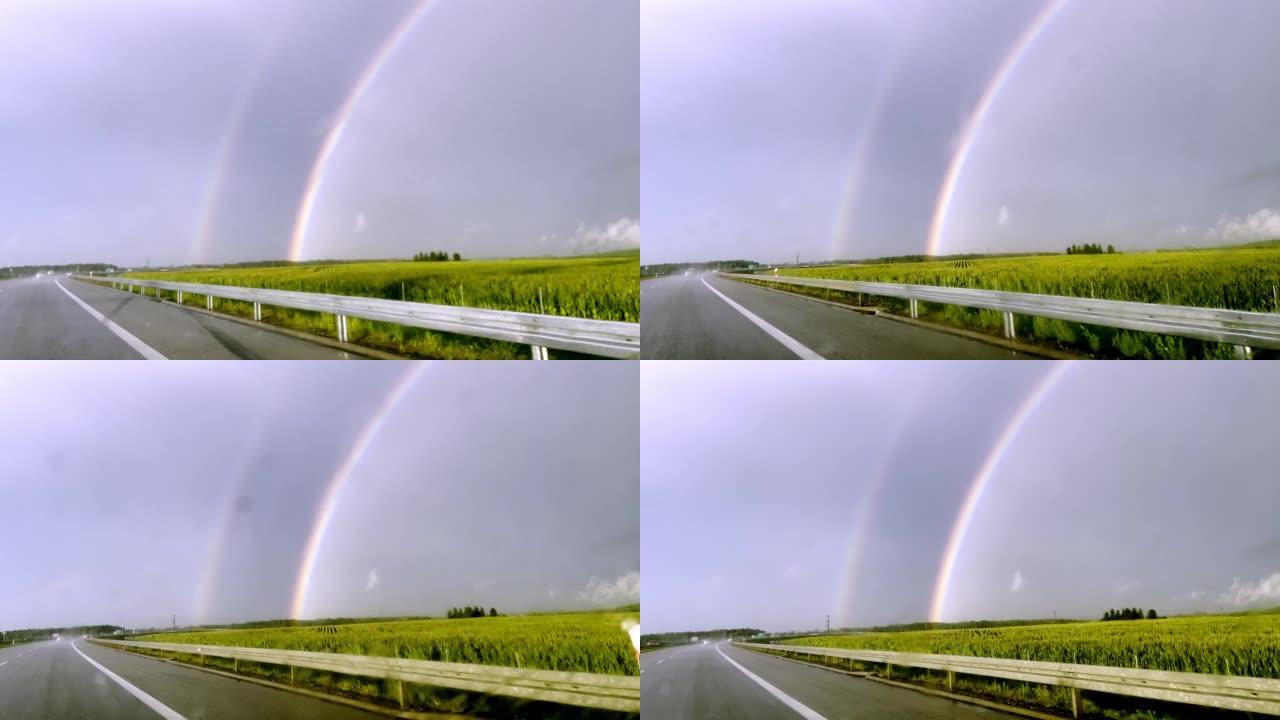 POV汽车驾驶。在雨中追逐彩虹