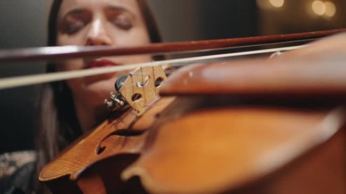 才华横溢的女小提琴手在音乐厅现场拉小提琴，手中的小提琴特写