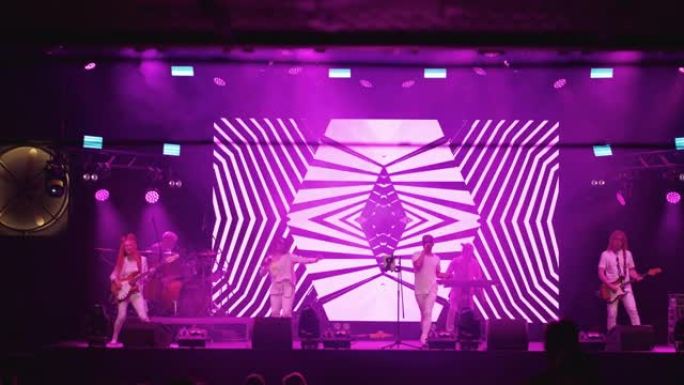 舞台上时尚摇滚乐队的惊人演出，正面视图，展示现代霓虹灯图形