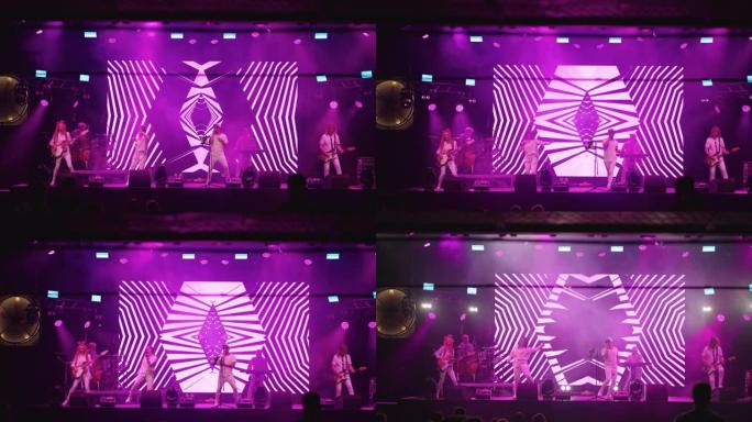 舞台上时尚摇滚乐队的惊人演出，正面视图，展示现代霓虹灯图形