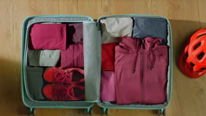 LD女人将运动服装进手提箱旅行