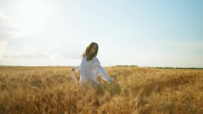 快乐无忧无虑的女人在阳光明媚的夏日独自奔跑在金黑麦球场上，慢动作拍摄