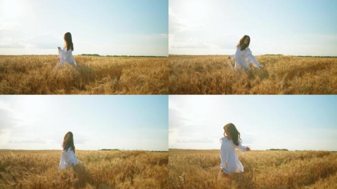 快乐无忧无虑的女人在阳光明媚的夏日独自奔跑在金黑麦球场上，慢动作拍摄