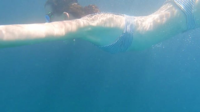 女人深呼吸，潜入大海。夏季带面罩浮潜