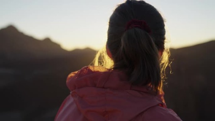 看着山日落的年轻女子。宁静的风景