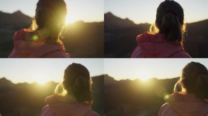 看着山日落的年轻女子。宁静的风景
