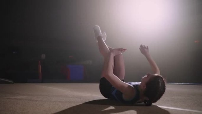 初级女体操运动员在体育馆表演后空翻，艺术体操比赛