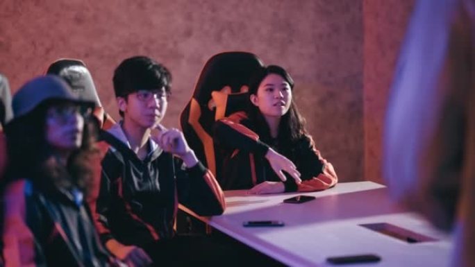 亚洲Esport团队在会议室举行的最后一场电子游戏比赛前听取教练分析简报策略