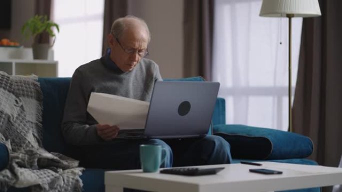 老人正在检查水电费并在家中使用笔记本电脑，退休人员正在计算他的费用