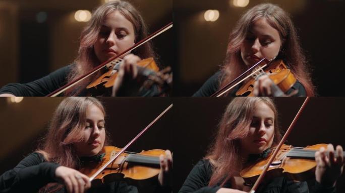 漂亮的年轻女子在音乐厅，肖像的现场在交响乐团中演奏小提琴