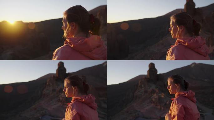 看着山日落的年轻女子。宁静的风景