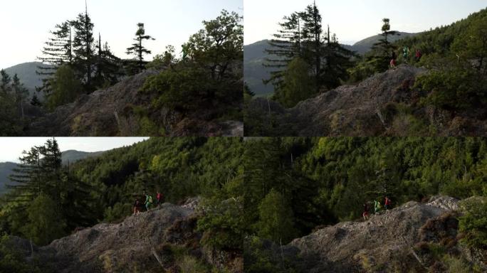空中无人机拍摄了三名山地车手从岩石山脊上爬下来的镜头