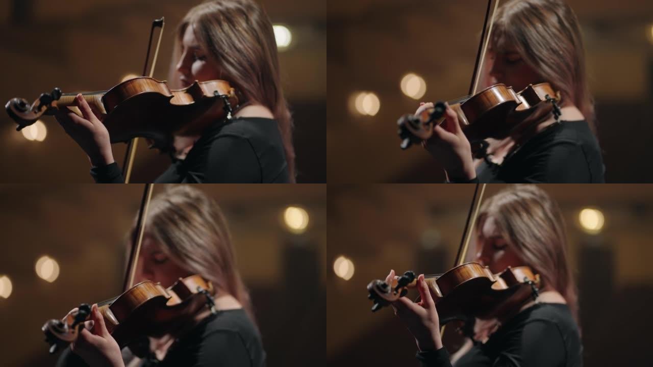 成年女小提琴手在歌剧院或音乐厅演奏小提琴，是女音乐家的肖像