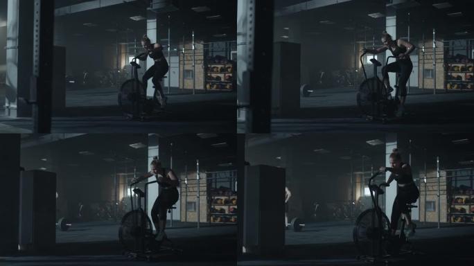 穿着黑色运动服的美女正在健身房的固定自行车上进行激烈的训练，全长射击