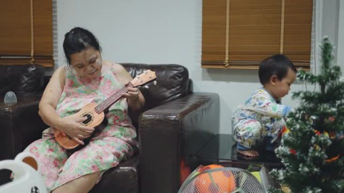 资深女子在家与男婴弹吉他