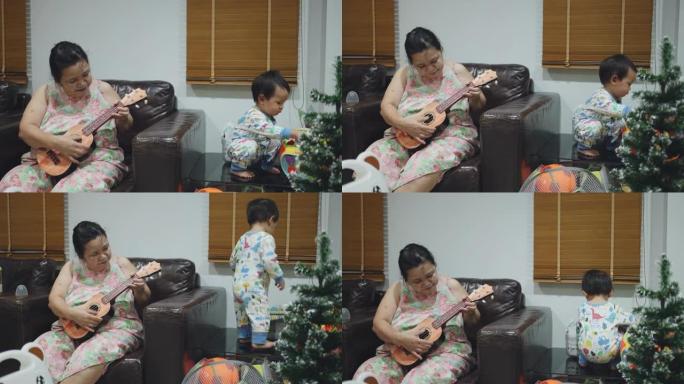 资深女子在家与男婴弹吉他