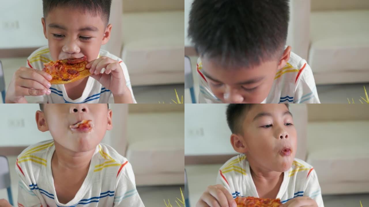 快乐的亚洲小男孩5年坐在家里的桌子上吃巨大的披萨