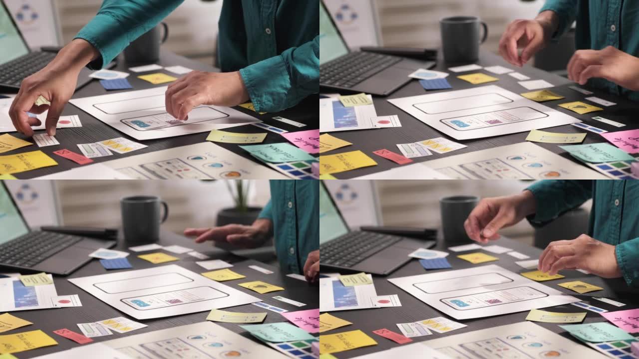 ux/ui开发人员的手在办公室的桌子上设计移动应用程序的特写