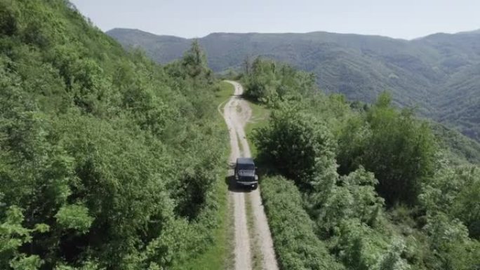 空中无人机拍摄了一辆沿着山区道路行驶的车辆