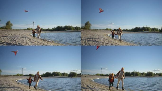 母女俩一起在湖岸刮风的天气里放风筝。家人一起放松