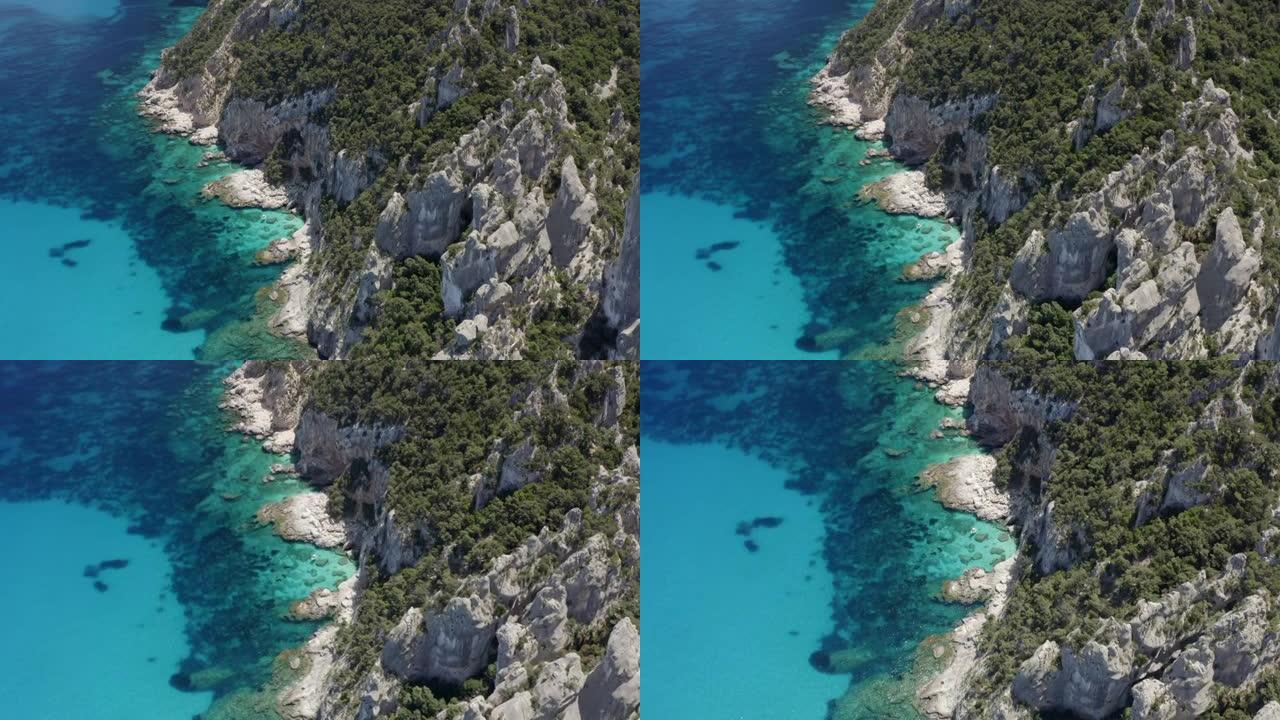 在阳光明媚的日子里，空中无人机拍摄了一个岛屿的岩石海岸线