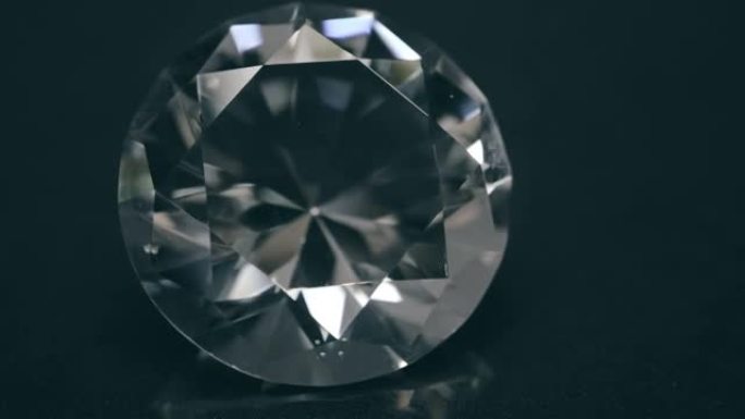 一颗美丽、昂贵的钻石在黑色闪亮的表面上旋转