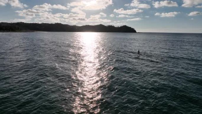 女性站立桨板冲浪者 (SUP) 的鸟瞰图在海浪中冲浪