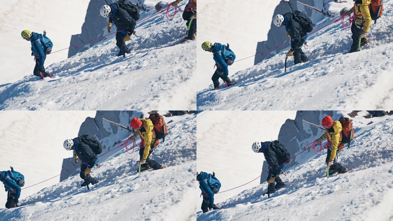 一队登山者在陡峭的山峰上移动。使用绳索和攀爬设备