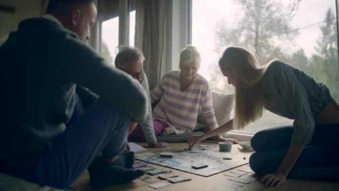 年轻的已婚夫妇与年迈的祖父母一起在桌子上玩棋盘游戏