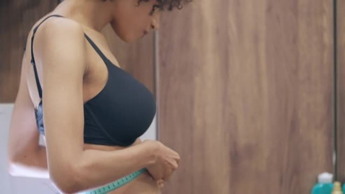 苗条的女性用胶带测量腰围，饮食失调，身体护理，厌食