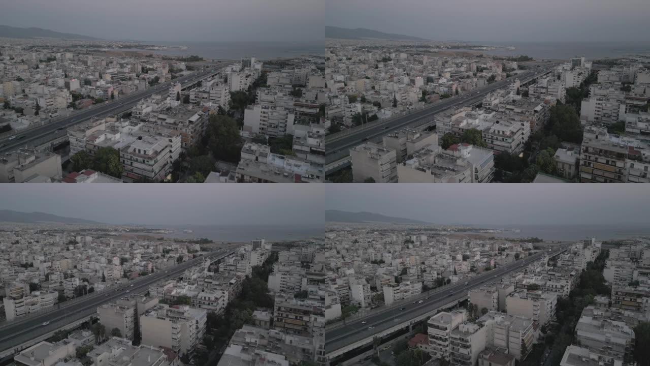 黄昏时在希腊法利罗的南雅典的交通枢纽和高速公路上慢动作2x飞行的空中4k镜头