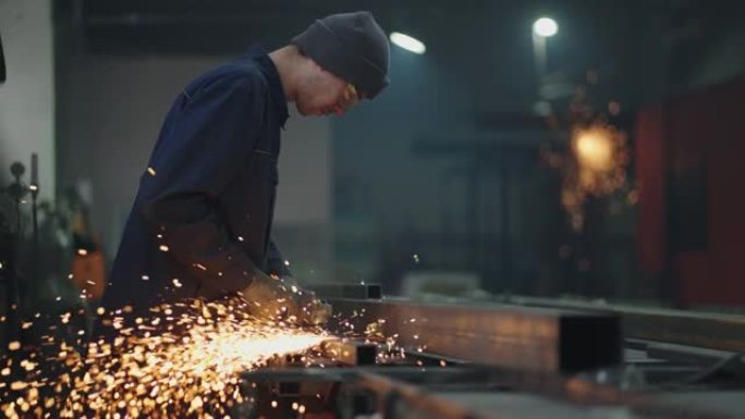 一名工厂工人在焊接后研磨金属。生产室工人在慢动作中研磨金属火花
