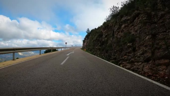 时间流逝，公路自行车手在蜿蜒的山路上爬坡的POV镜头