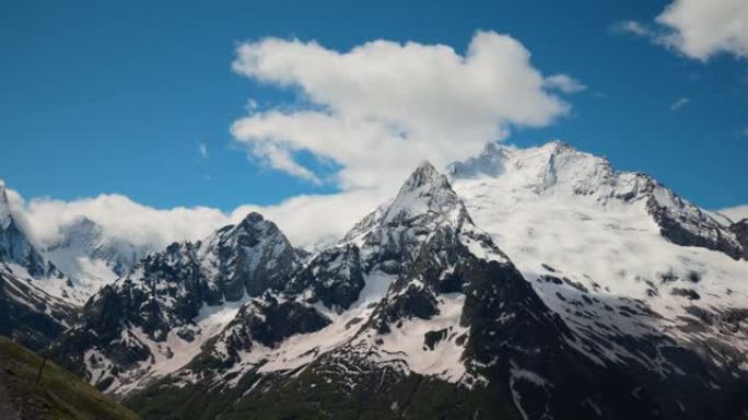 空中飞行穿过山云，飞越美丽的白雪皑皑的山峰和冰川。