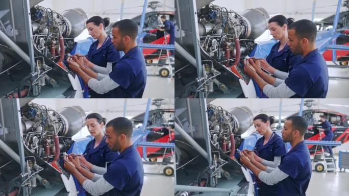 在直升机发动机上工作的DS男女航空机械师