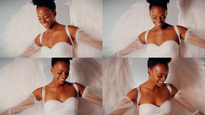 美丽的非洲女人，有着白色的天使翅膀，微笑着往下看。慢动作