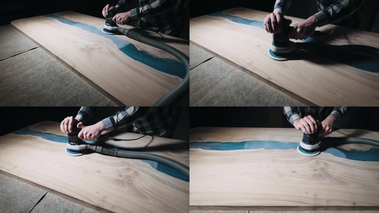 木匠用研磨机加工木制桌面的表面。用环氧树脂填充的板坯。