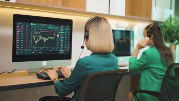 金融分析师在工作站监控股票市场和交易所。