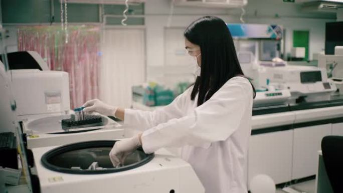 医疗技术人员，在血液实验室使用纺纱机。