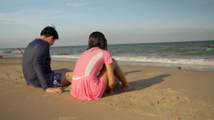亚洲儿童在海滩上享受快乐和放松，晚上一起阳光，户外生活方式理念。