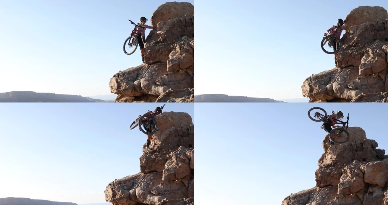女山地车手将自行车骑上陡峭的岩石顶峰