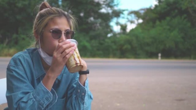 Asian Hipster woman is drinking ice coffee on the 