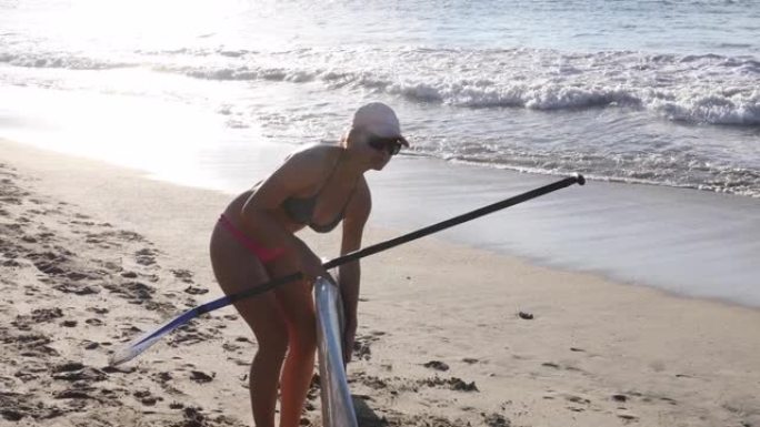 女性站立冲浪者 (SUP) 通过冲浪划桨