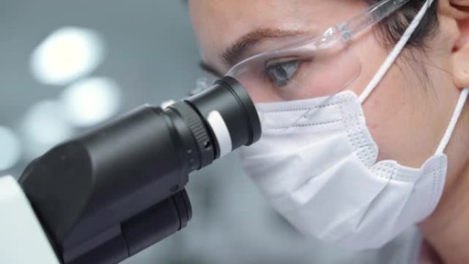 显微镜室的近距离实验室技术人员研究和开发抗病毒药物。