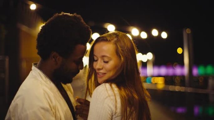 跳舞和爱。年轻多样的夫妇在潮湿的城市街道上表演性感舞蹈。夜晚的浪漫场景。特写镜头。