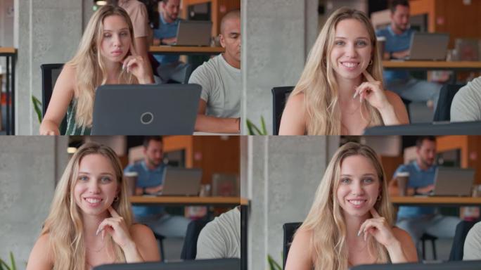 SLO MO年轻女子在工作空间中使用笔记本电脑时微笑