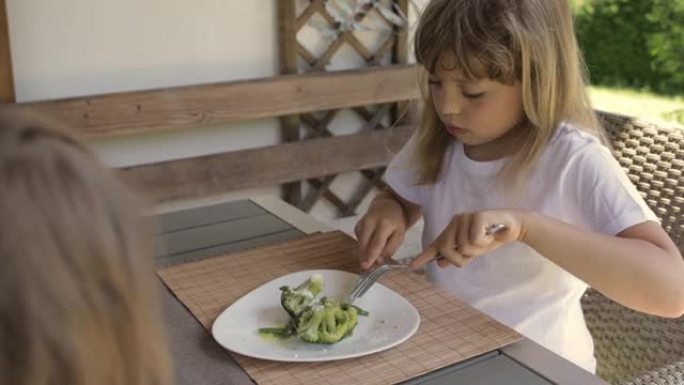 7岁的高加索女孩以西兰花作为午餐。