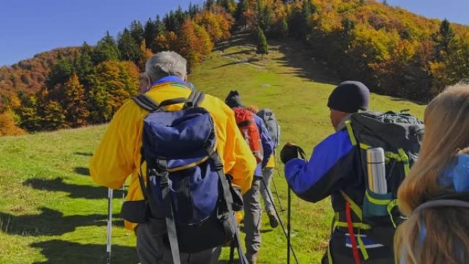 POV和一群资深徒步旅行者一起走在阳光明媚的山坡上