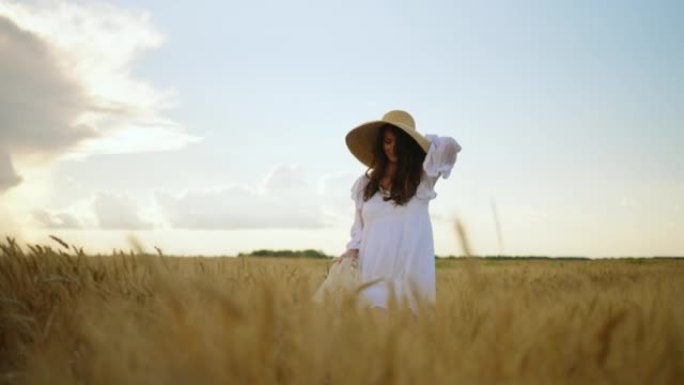 夏日平静美丽的女人独自走在金色的麦田上，美女的肖像